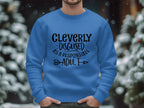 A person outdoors wears a blue Garment Graphics Cleverly Disguised as a Responsible Adult sweatshirt in unisex sizing, embodying humorous chic. Snow and blurred trees create a serene backdrop, enhancing the playful vibe of these sweatshirts.