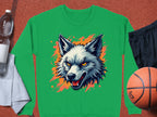 A Garment Graphics green wolf face sweatshirt features a wolfs head graphic with sharp eyes and an open mouth, set against an orange splash design. Styled with a basketball, black shorts, water bottle, and towel for a sporty vibe.