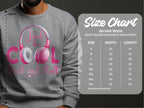 Clad in a trendsetting statement piece, someone wears a gray sweatshirt by Garment Graphics with Just be Cool Rock and Roll in pink headphones. The size chart for the Gildan 18000 Heavy Blend Crewneck Sweatshirt ranges from S to 5XL, ideal for music lovers desiring comfort and style.