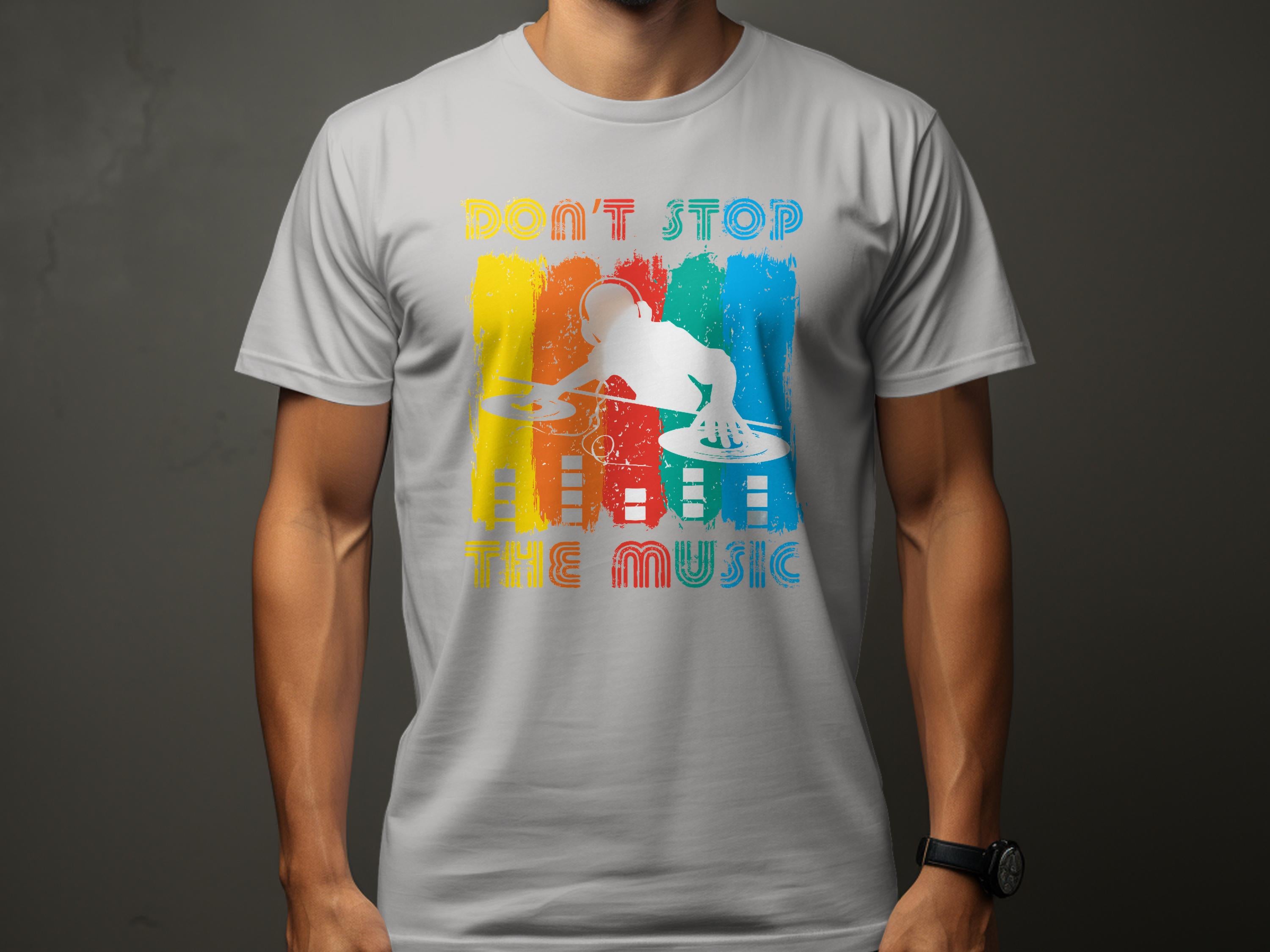A person displays a Garment Graphics gray t-shirt featuring a vibrant DJ design with yellow, red, and blue stripes. It proudly states Dont Stop the Music, perfect for music enthusiasts. They pose against a plain, dark background.