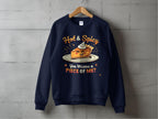 A navy blue unisex sweatshirt by Garment Graphics hangs on a wooden hanger against a concrete wall. It features an illustration of a smiling cheese block with sunglasses and whipped cream, plus the playful text: Hot & Spicy Sweatshirts: You Wanna a Piece of Me?.