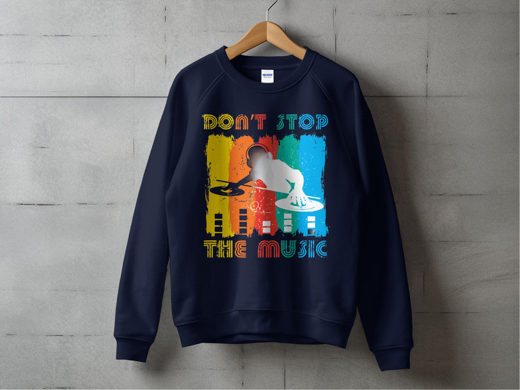 A navy DJ sweatshirt by Garment Graphics hangs on a wooden hanger against a concrete wall, ideal for music lovers. It features a silhouette DJ with turntables against a colorful backdrop and bold text Dont Stop the Music, available in unisex sizing.