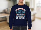 A person wearing a navy sweatshirt from Garment Graphics Fishing Passion Apparel line shows off the message: I’d rather have a bad day fishing than a good day at work. This unisex fishing sweatshirt showcases decorative typography in multiple colors.