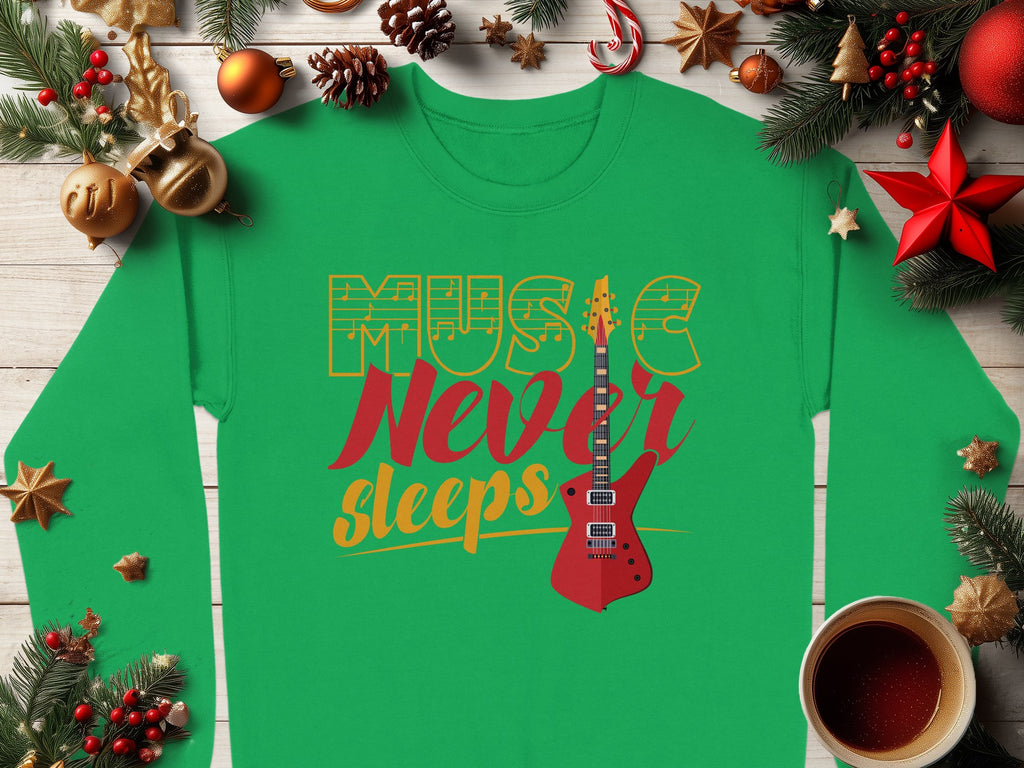 Garment Graphics presents a vibrant green guitar-themed sweatshirt adorned with Music Never Sleeps in bold red and yellow. Ideal for music lovers, it features an eye-catching electric guitar amid festive Christmas decor, ornaments, pine branches, and a steaming coffee cup on a wooden table.