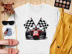A flat lay features a vibrant Garment Graphics sweatshirt with a racing car and checkered flags, perfect for motorsport fans. The scene includes makeup brushes, sunglasses, a makeup palette, lipstick, a ring pouch, pink loafers, and a mustard blazer.