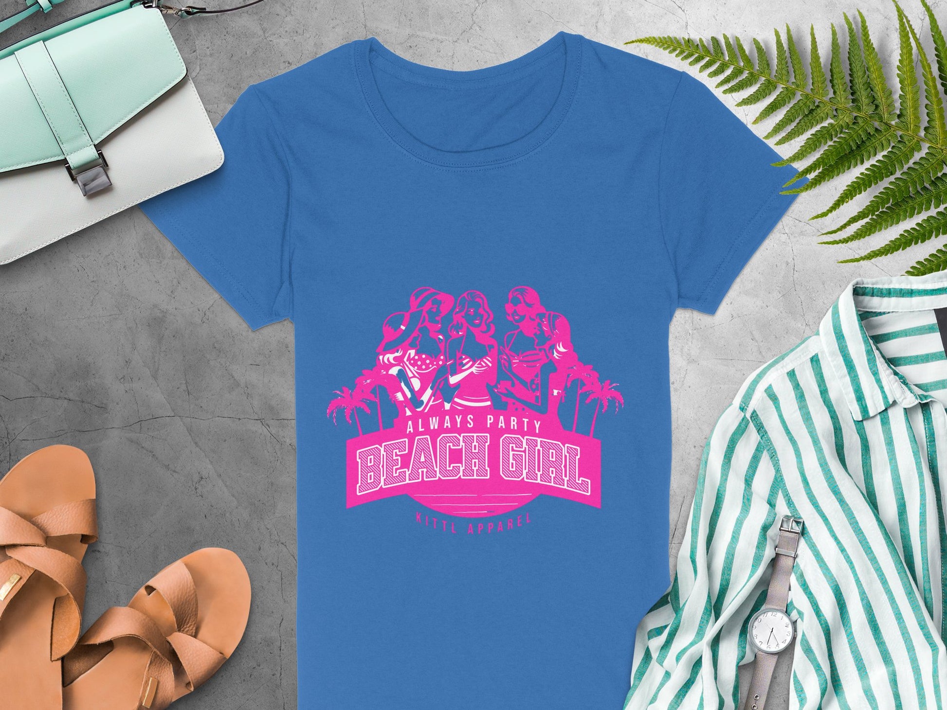 Blue t-shirt featuring a pink graphic of three dancing women with Always Party Beach Girl and Ninth Apparel, surrounded by a purse, sandals, striped shirt, watch, and fern leaves on gray. Ideal for Womens Semi-Fitted Tee lovers from Garment Graphics.