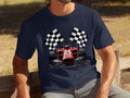 A motorsport enthusiast, wearing a Garment Graphics navy blue T-shirt with a red Formula 1 car and crossed checkered flags design, is seated outdoors on a wooden bench.