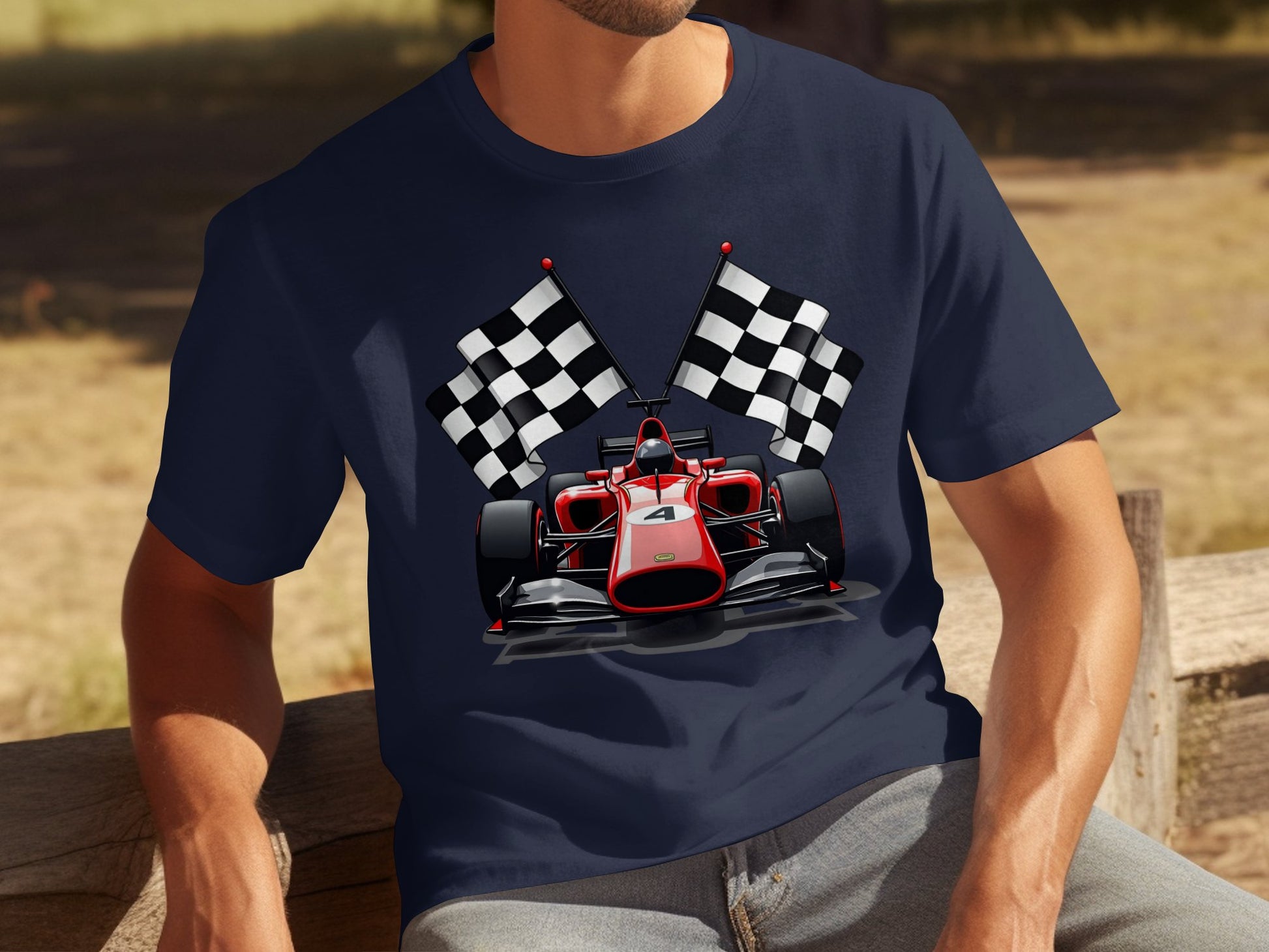 A motorsport enthusiast, wearing a Garment Graphics navy blue T-shirt with a red Formula 1 car and crossed checkered flags design, is seated outdoors on a wooden bench.