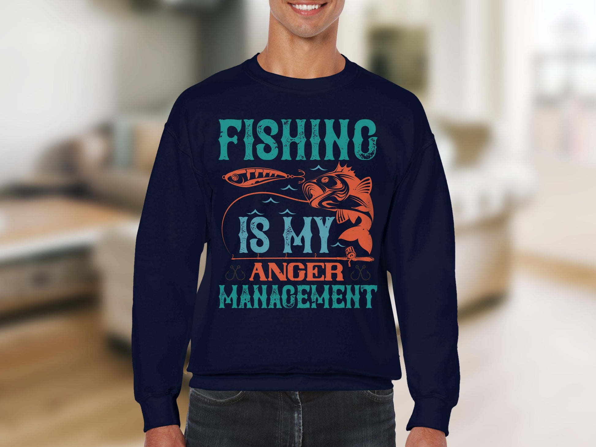 A fishing enthusiast sports a Garment Graphics navy sweatshirt with Fishing Is My Anger Management boldly emblazoned, featuring a vibrant fish and lure against a blurred indoor backdrop—perfect for capturing the true spirit of every angler.