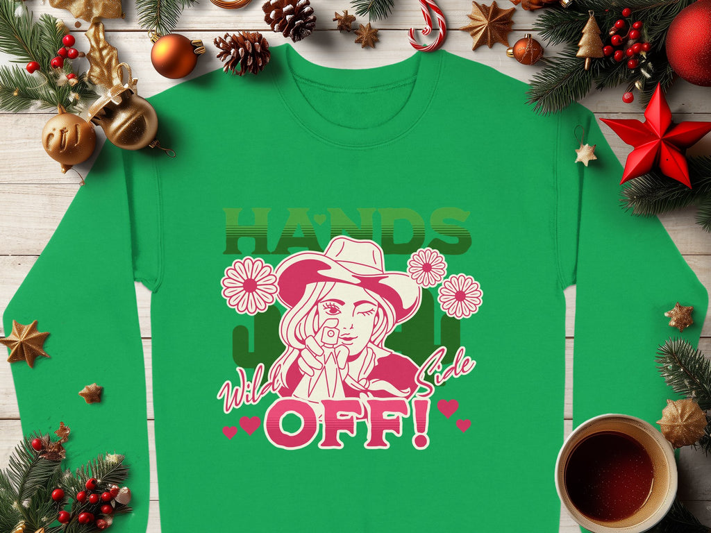 Discover Garment Graphics Wild Side Sweatshirt in green, boasting bold graphics of a person with a rose and the text HANDS OFF! It features holiday accents like pine branches, ornaments, candy canes, and coffee. Available in unisex sizing for ultimate comfort.