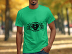 A person outdoors wears a vivid Garment Graphics T-shirt featuring a Scania V8 Power logo. The background is blurred, highlighting a tree-lined walkway with stunning autumn hues.
