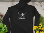 The Garment Graphics Freebird Graphic Pullover Hoodie features a bird with outstretched wings and Freebird beneath. On a concrete background, its artfully surrounded by green leaves, red roses, and yellow flowers, highlighting its distinct style.