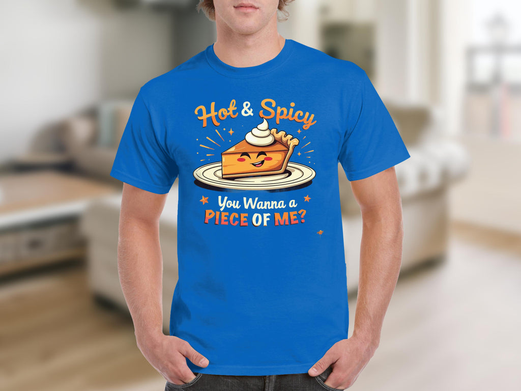 A person is wearing a Garment Graphics blue T-shirt with a Hot and Spicy Pie Design, showcasing a pie slice topped with whipped cream. The shirt says, You Wanna a Piece of Me? The backdrop is a blurred indoor scene.