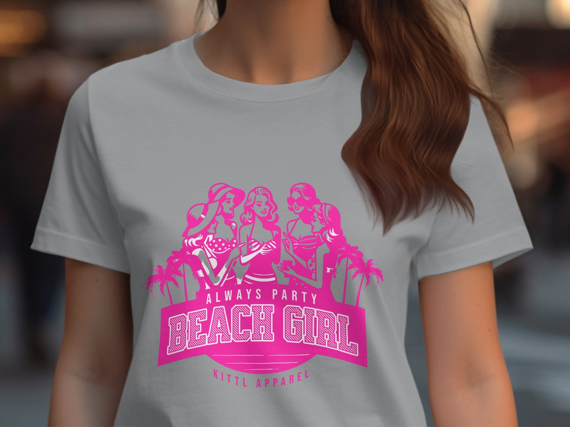 A person dons a light gray t-shirt with a pink graphic of three stylized women and palm trees. It reads Always Party Beach Girl - Kittl Apparel. This Womens Semi-Fitted Tee from Garment Graphics blends style and comfort, perfect for any beach-loving fashionista.