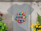 The Garment Graphics 100% cotton gray T-shirt showcases a vibrant balloon graphic with Happy Birthday text. Set against a textured background, its adorned with green plants and yellow flowers, making it ideal for birthday celebrations.