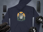 A Garment Graphics navy blue classic fit hoodie with owl artwork is displayed on a gray surface, surrounded by a smartphone, smartwatch with strap, black sneakers, portable speaker, and adjustable dumbbells.