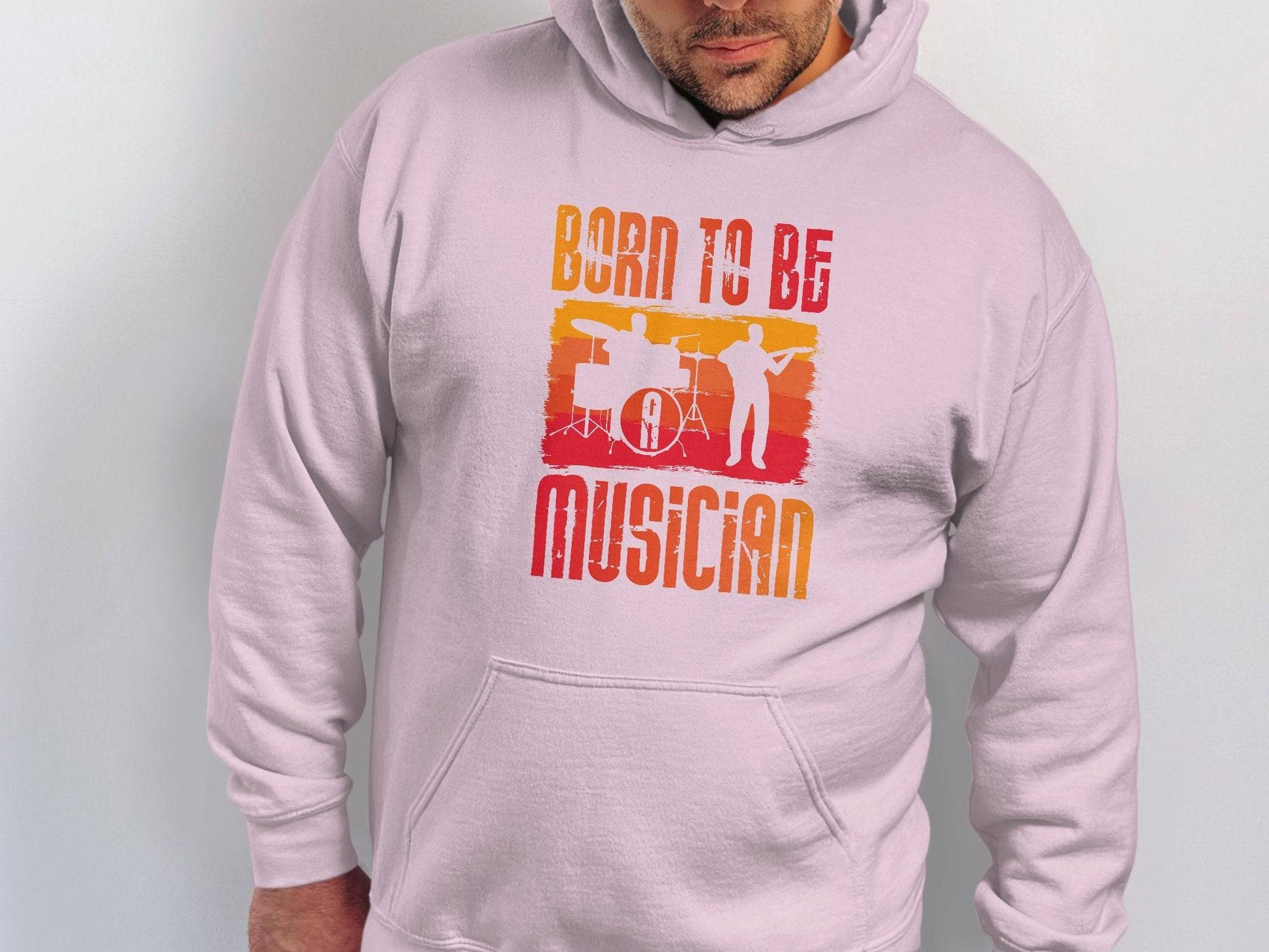 Wearing Garment Graphics white unisex hoodie, adorned with vibrant red and orange musician silhouettes and BORN TO BE A MUSICIAN text, makes a perfect choice for music lovers seeking a colorful statement piece.