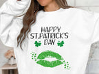 A person in a Garment Graphics white sweatshirt celebrates St. Patricks Day with festive zest, featuring green shamrocks, a bold clover kiss print, and Happy St. Patricks Day, their face obscured by long, wavy brown hair.