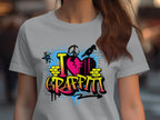A person wearing a Garment Graphics light gray T-shirt with urban I Love Graffiti designs in vibrant pink, yellow, and blue, featuring paint splatters and a heart icon.