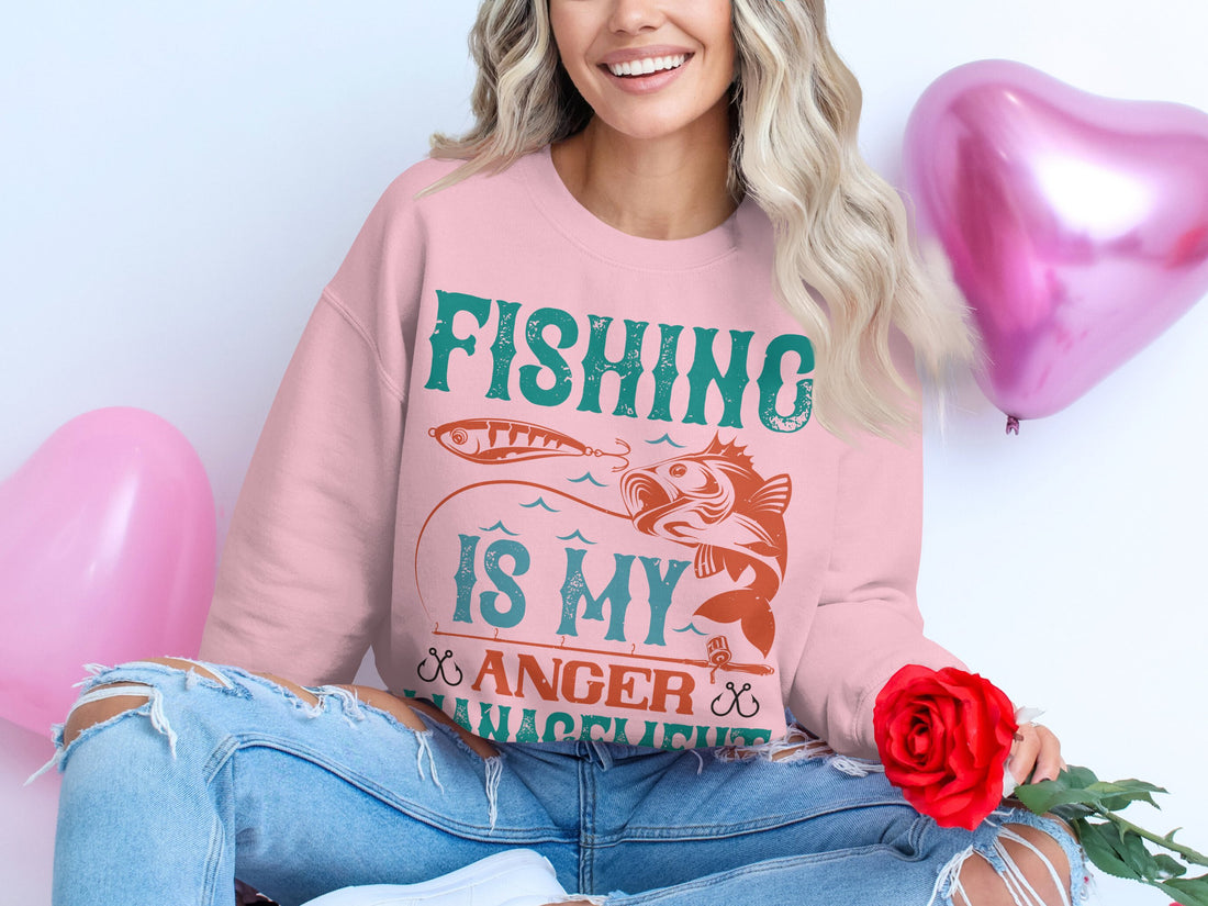 Garment Graphics presents a white T-shirt featuring Fishing Is My Anger Management with a fish and hook design, styled alongside a yellow jacket, pink shoes, sunglasses, makeup brushes, nail polish, and an eyeshadow palette on a wooden surface. Perfect for fishing enthusiasts.