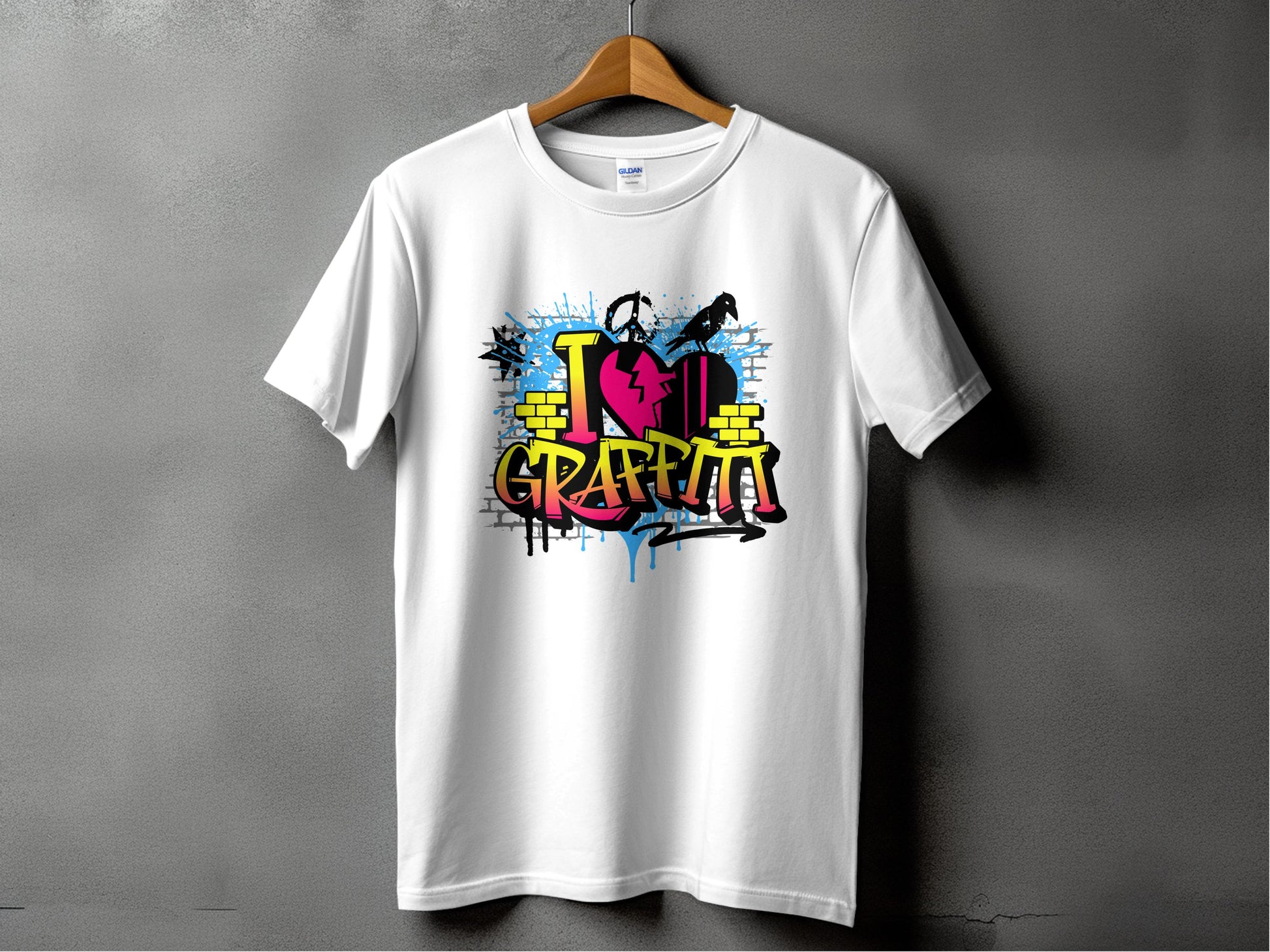 A white T-shirt from Garment Graphics hangs on a wooden hanger against a gray wall. It features vibrant street art with graffiti-style text I Love Graffiti, paint splatters, and a silhouette of someone holding a spray can, embodying the Graffiti Love T-Shirts essence.