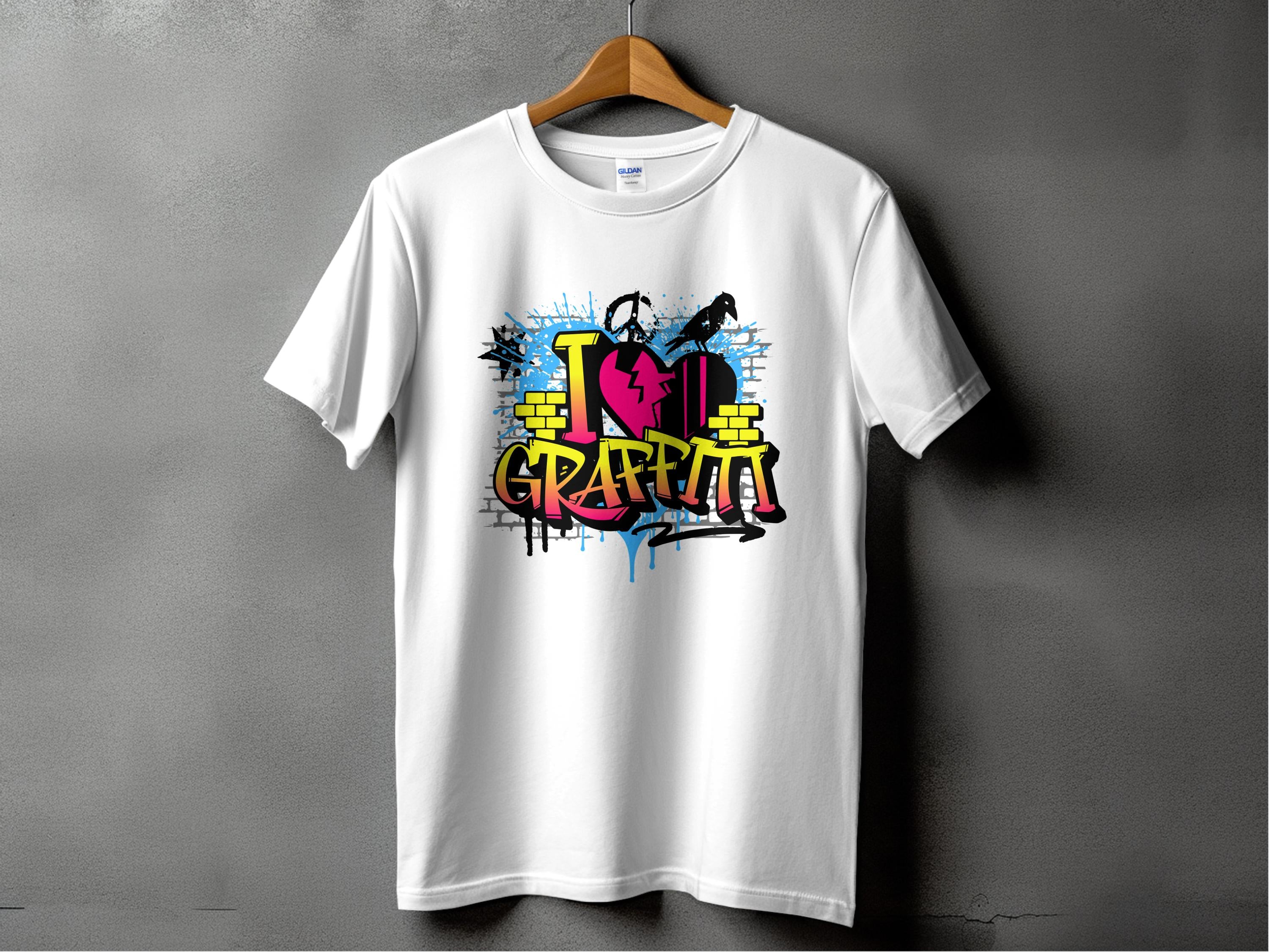A white T-shirt from Garment Graphics hangs on a wooden hanger against a gray wall. It features vibrant street art with graffiti-style text I Love Graffiti, paint splatters, and a silhouette of someone holding a spray can, embodying the Graffiti Love T-Shirts essence.