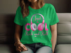 A music lover wears a green Garment Graphics t-shirt featuring Just be COOL Rock and Roll and headphone graphics. Seated against a softly blurred background, the essence of headphones t-shirts for rock and roll fans is perfectly showcased.