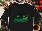 A Garment Graphics sweatshirt features Happy St. Patricks Day in green above a shamrock-laden truck, surrounded by festive pine cones, stars, a red bow, and a coffee cup in the corner.