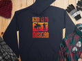 Garment Graphics offers a black unisex fashion hoodie featuring silhouettes of a drummer and guitarist with Born to be Musician in orange and red. Perfect for music lovers, its styled with winter essentials like a beanie, gloves, and plaid shirts on a wooden surface.