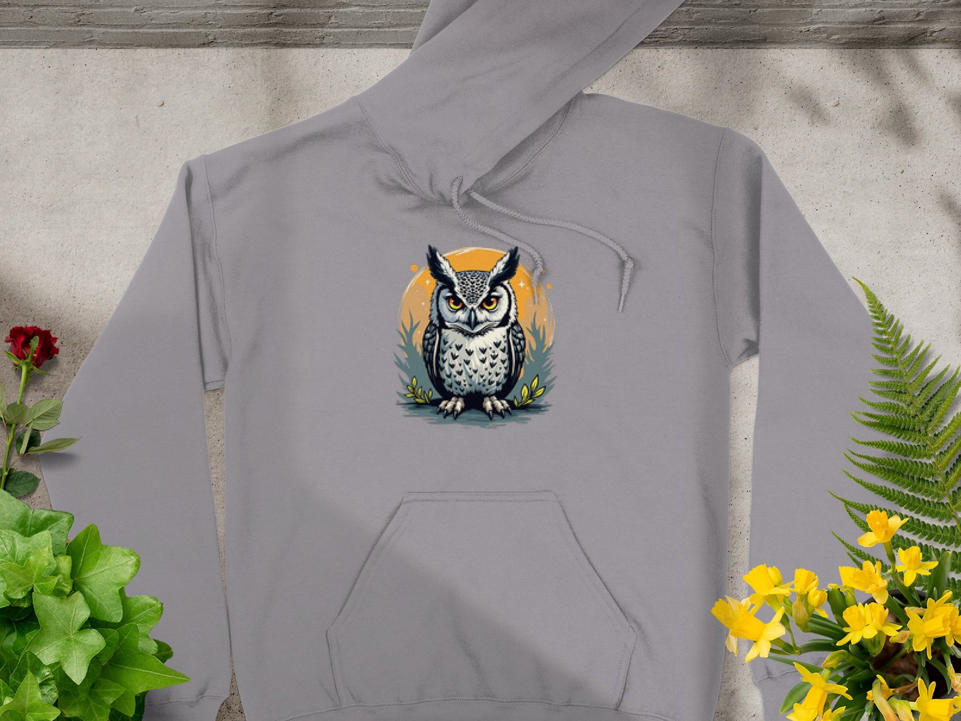 Introducing Garment Graphics Fierce Owl Illustration Hoodies: a gray medium-heavy fabric hoodie showcasing an illustrated owl with an orange and blue circle on textured gray, surrounded by green and yellow plants for a unique style.