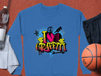 A blue Garment Graphics sweatshirt with I Love Graffiti in vivid letters is paired with a towel, a water bottle, black shorts, and an orange basketball, capturing the vibrant essence of street art.