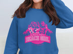 A person wearing a blue sweatshirt from Garment Graphics with a pink graphic design featuring three women, palm trees, and the bold text Always Party Beach Girl.