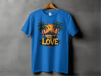 A blue T-shirt from Garment Graphics hangs on a wooden hanger against a gray background, featuring a tropical sunset design with palm trees, a bird in flight, and ONE LOVE boldly printed—ideal for beach enthusiasts.