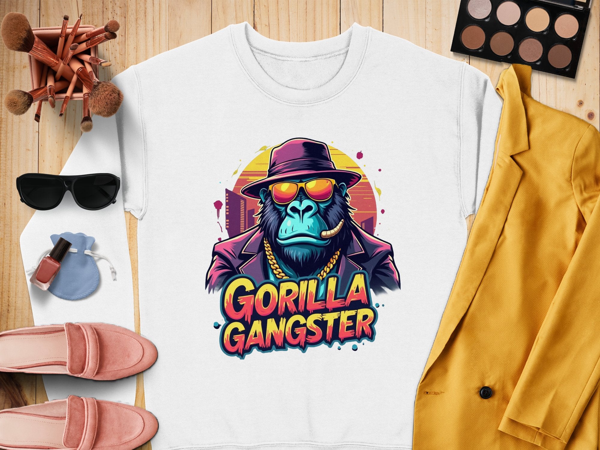 The urban white sweatshirt by Garment Graphics features a gorilla in a hat, sunglasses, and gold chain with a cigar. Gorilla Gangster is printed below. It pairs well with brushes, makeup, shoes, sunglasses, and a vibrant yellow jacket.
