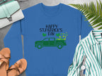 Garment Graphics festive sweatshirt displays a green truck with shamrocks and Happy St. Patricks Day text on blue. Styled flat, its paired with sandals, a striped shirt, watch, green purse, and ferns.