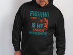A person wearing a black hoodie from Garment Graphics featuring the text Fishing is my anger management in teal and orange. With a fish graphic, this Anglers Wardrobe piece is perfect for any fishing enthusiast.