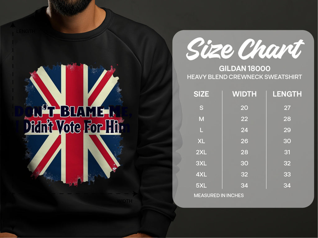 A person wears a black Garment Graphics sweatshirt with a Union Jack and Dont Blame Me, I Didnt Vote For Him text, standing by a size chart for the cozy Gildan 18000 featuring sizes S to 5XL with inch measurements.