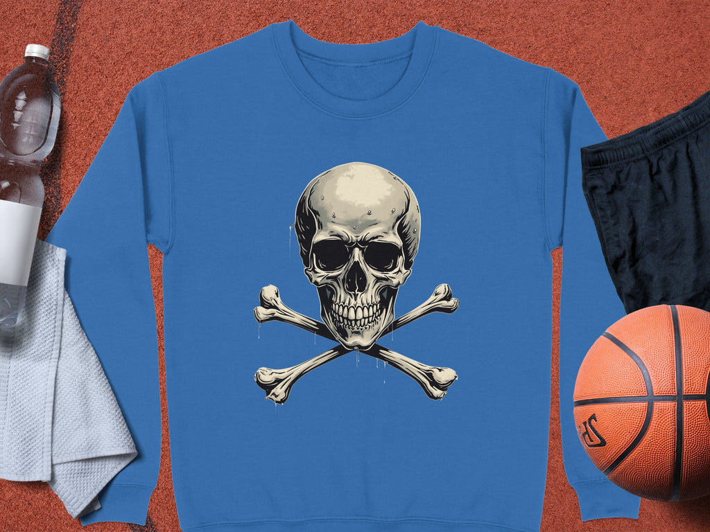A bold and edgy blue sweatshirt featuring a skull and crossbones graphic print by Garment Graphics is centered in the image. It is surrounded by a water bottle, white towel, black shorts, and a basketball on a red textured surface.