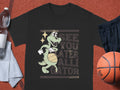 Garment Graphics black T-shirt is ideal for casual wear, showcasing a cartoon alligator spinning a basketball with See You Later Alligator printed behind it. It is stylishly paired with a water bottle, towel, and basketball.