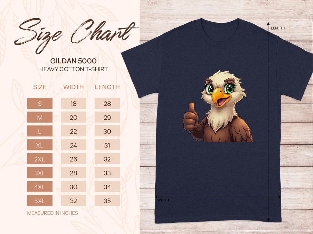 A size chart for a classic fit Garment Graphics Gildan 5000 heavy cotton tee is on wood, detailing sizes S to 5XL, including widths and lengths in inches. Next to it, an Eagle T-shirt with a cartoon eagle giving a thumbs-up adds fun flair to your casual wardrobe.