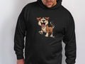 A person models a Garment Graphics black hoodie featuring a playful cartoon puppy—a brown and white dog with floppy ears and a cheerful expression. Perfect for dog lovers, the pup stands on hind legs, while the person’s face remains mostly out of frame.