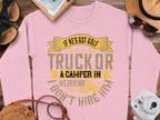 Garment Graphics humorous pink sweatshirt features the text: If hes got golf clubs in his truck or a camper in his driveway, dont hire him. Displayed with sunglasses, a notebook, straw hat, photo, and phone on a wooden surface—ideal for those who love casual wear with a witty twist.