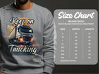A person wears a Garment Graphics gray sweatshirt featuring a bold truck graphic and Keep on Trucking. The Gildan 18000 Crewneck Sweatshirt size chart offers measurements from S to 5XL in inches for perfect fit guidance, capturing the spirit of the open road.
