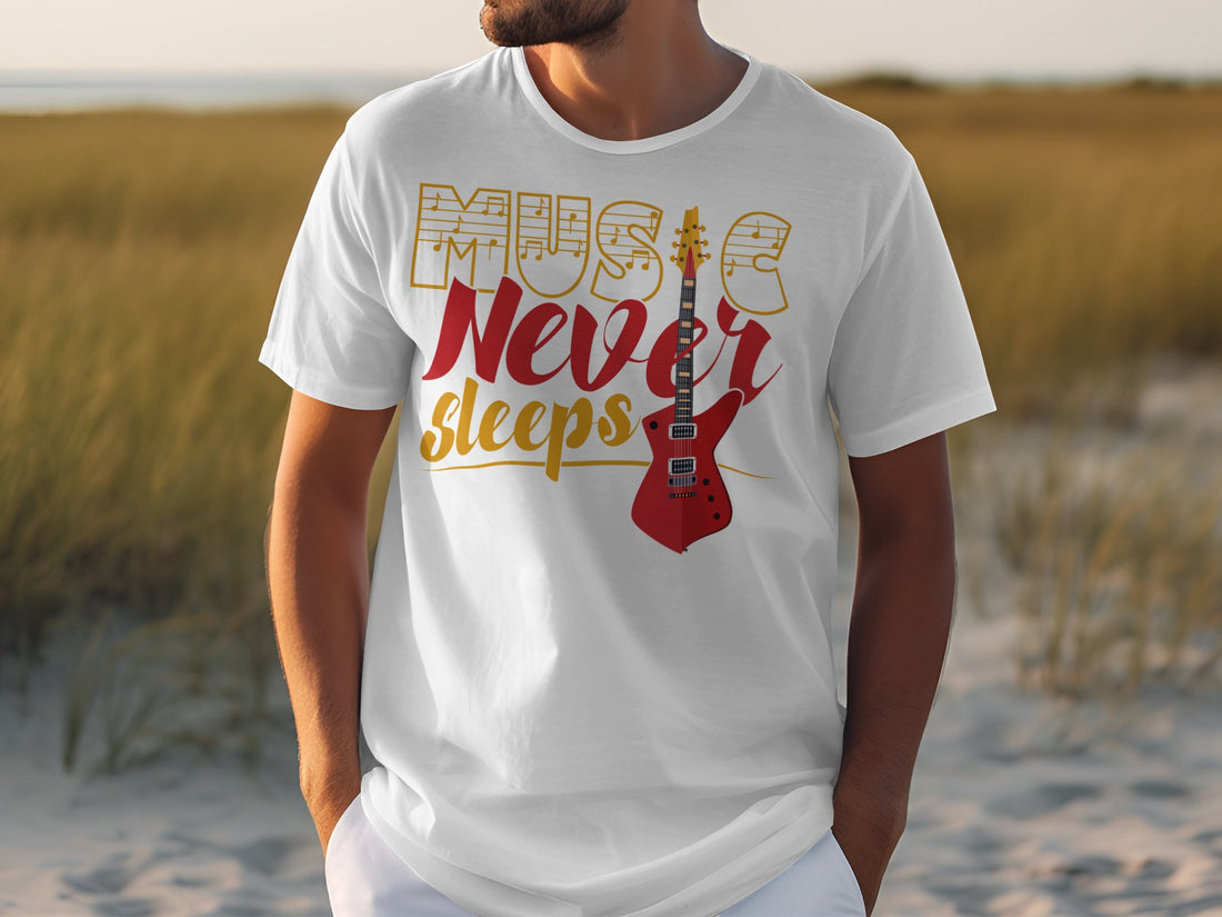 Garment Graphics blue 100% cotton t-shirt showcases a red electric guitar and the phrase Music Never Sleeps, capturing Graphic T-Shirts essence. Its styled in a flat lay with headphones, sunglasses, jeans, a brown shirt, wristwatch, and keys on a wooden surface.