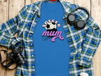 Garment Graphics blue Soccer Mum T-shirt, featuring a soccer ball graphic, paired with a plaid shirt, camera, headphones, and to-go coffee cup on wood. Perfect for every football-loving mom.