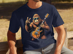 A person enjoys the outdoors in a Garment Graphics navy T-shirt with a sunglasses-wearing gorilla holding an electric guitar and making a peace sign. Ideal for music lovers, the sunny background includes benches and grass.