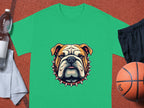 A Garment Graphics green T-shirt with a bulldog and spiked collar graphic is on a basketball court. To its left, theres a water bottle and white towel; to its right, black shorts and an orange basketball, ideal for family-sized adventures.