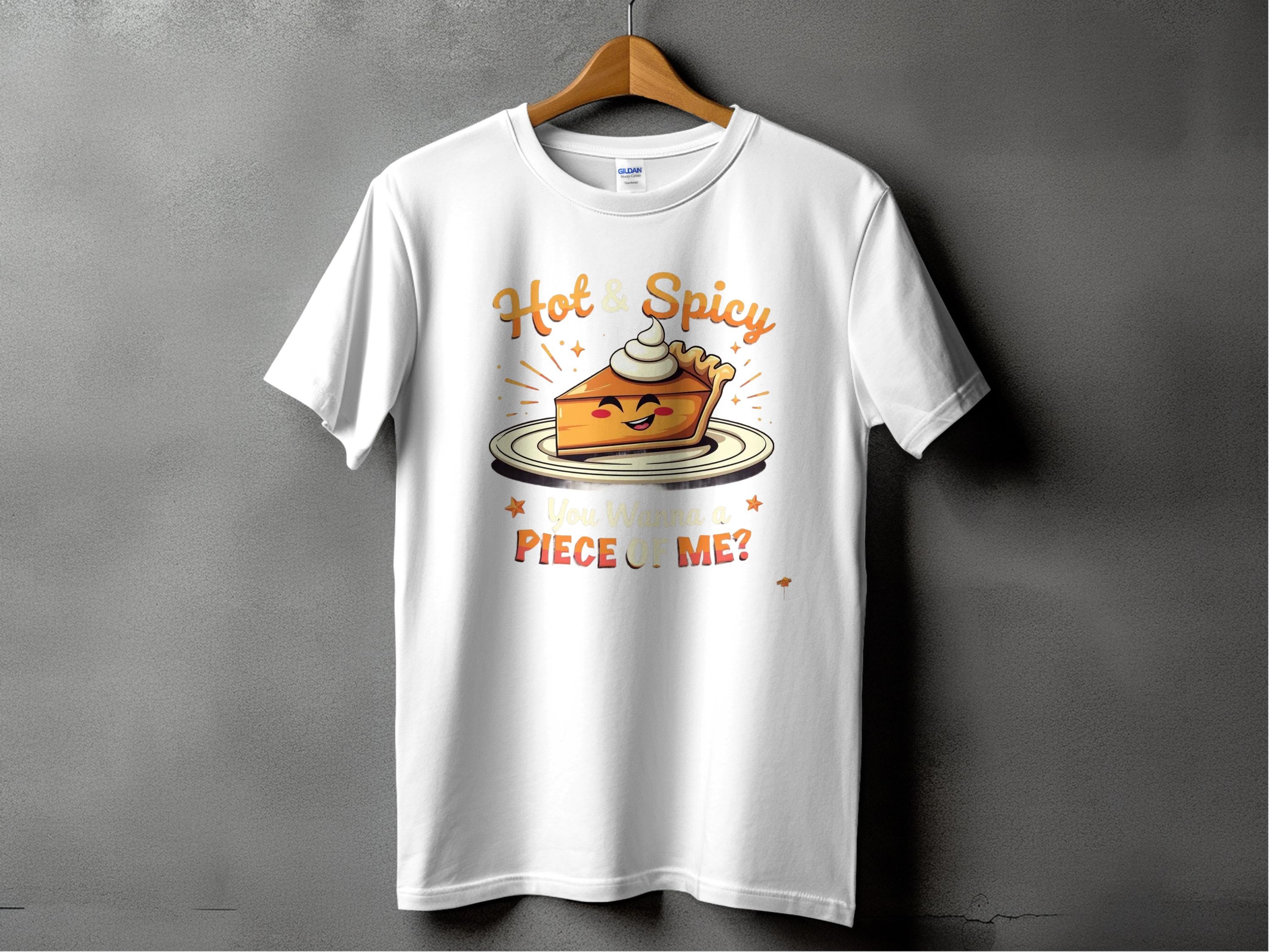 Garment Graphics presents a family-friendly white tee with the Hot and Spicy Pie Design, featuring a pie slice on a plate with whipped cream, Hot & Spicy text above, and You Wanna a Piece of Me? below, set against a dark gray background.