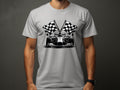 A person wears a Garment Graphics light gray T-shirt featuring a black and white Formula One race car illustration with checkered flags, while their face is unseen, capturing the motorsport essence.