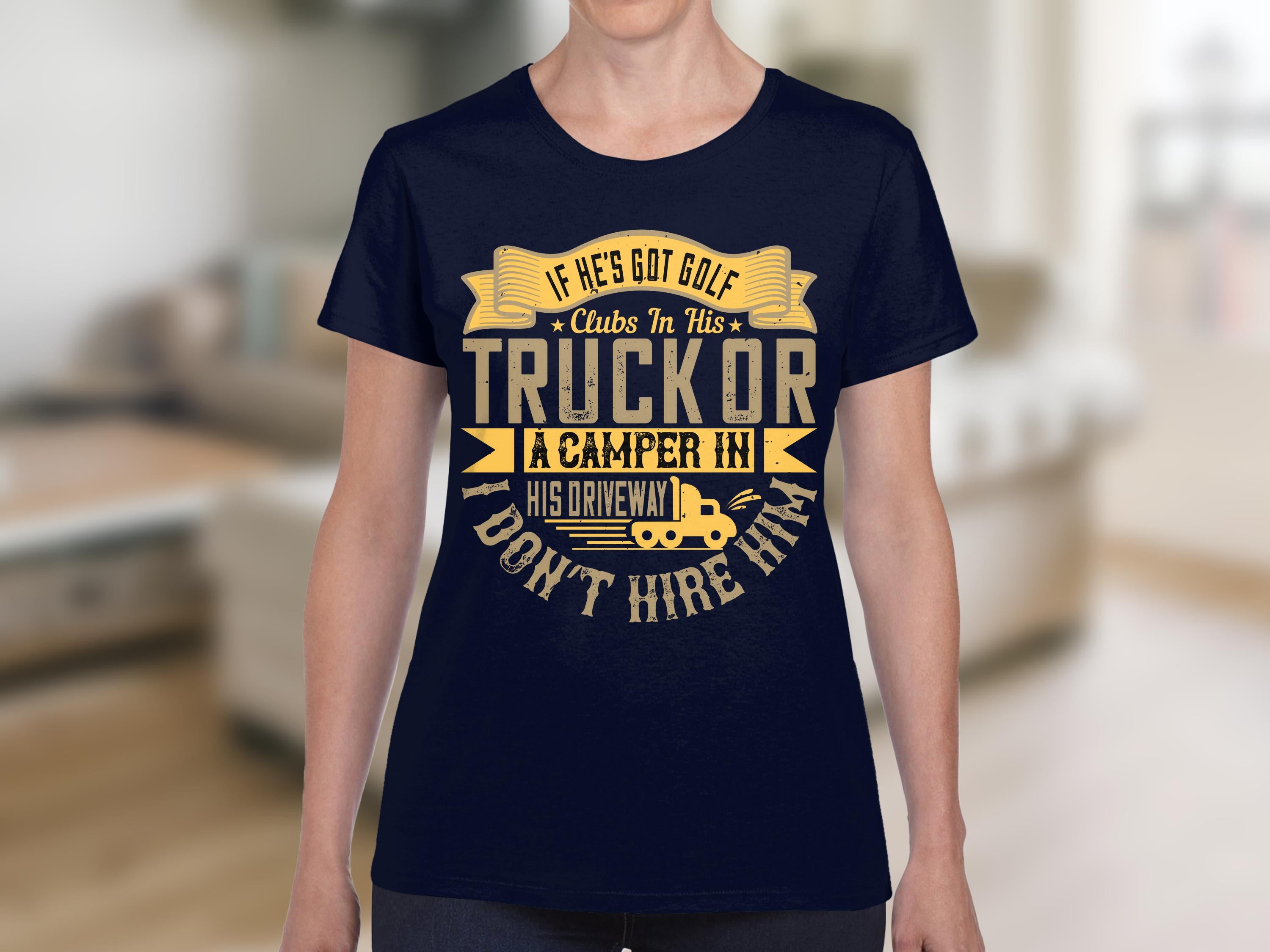 A person wears a Garment Graphics navy blue T-shirt featuring a humorous golf graphic with yellow text: If hes got golf clubs in his truck or a camper in his driveway, I dont hire him, making it pop against the blurred room background.
